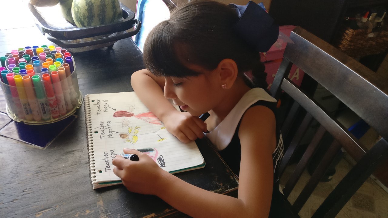 student drawing at kitchen table